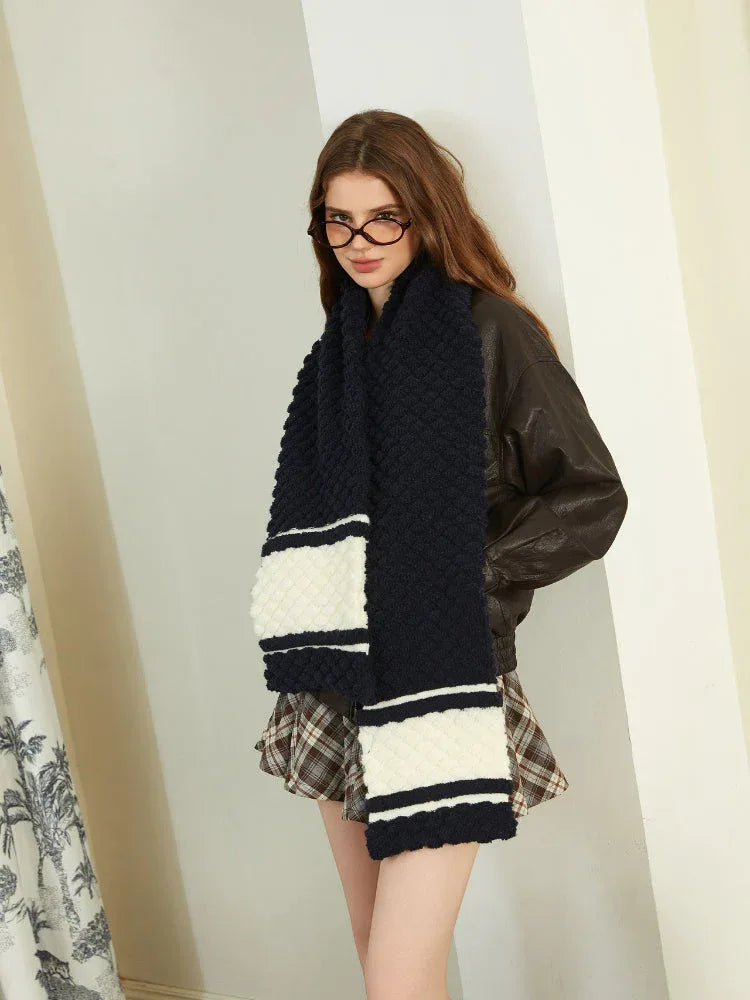 Close-up of a woman wearing a navy and white striped knit scarf