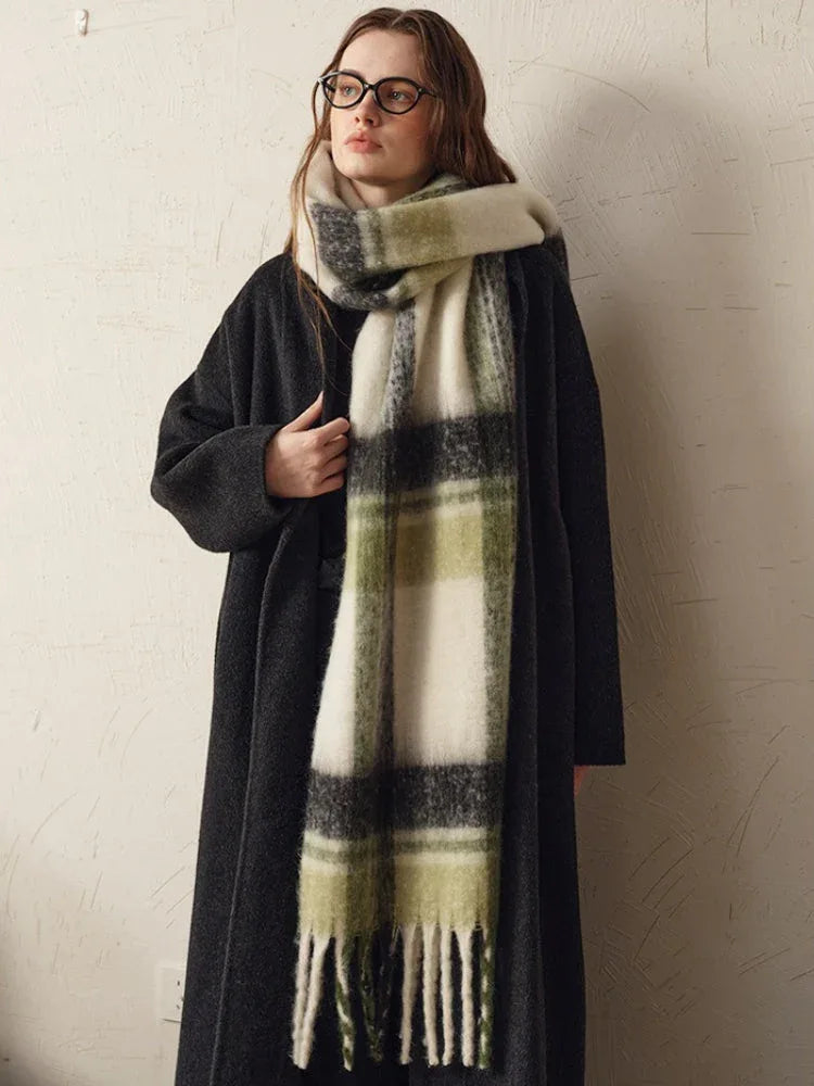 woman wearing a dark coat and a green and white plaid scarf, adjusting the scarf with her hand