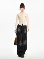 Full body shot of a woman wearing a cream cable knit cropped cardigan with black wide-leg jeans, a black belt, and a black fur bag