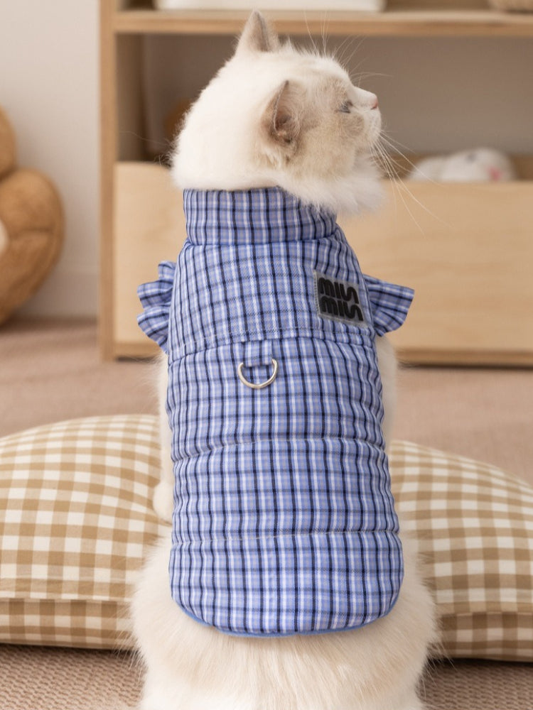 Rear view of a white cat wearing a blue plaid vest with ruffled sleeves.