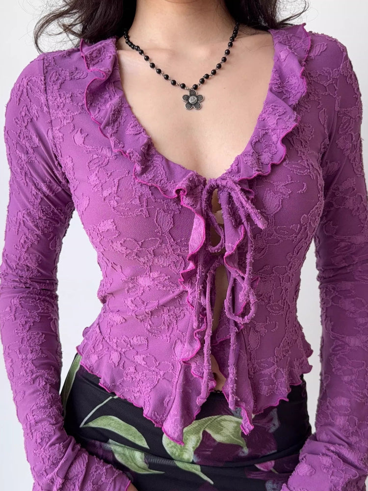 Detailed view of the neckline and tie-front closure of a purple floral lace top.