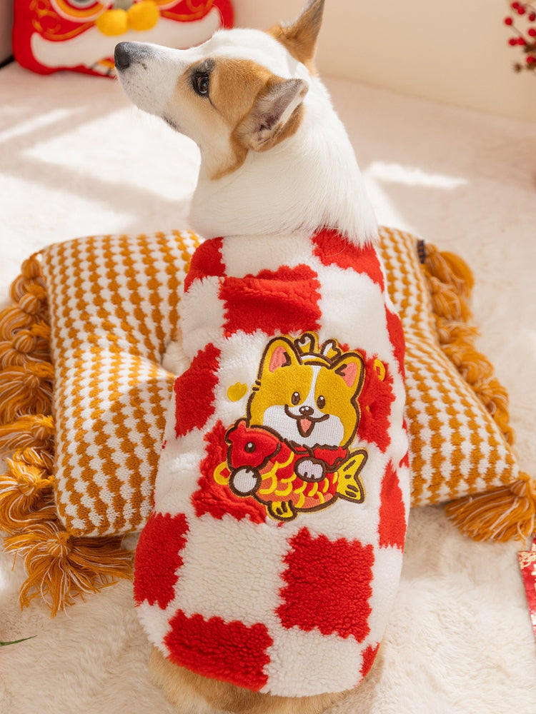 Back view of a corgi dog wearing a red and white checkered plush sweater with a cartoon embroidered graphic of a dog holding a fish.