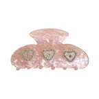Pink marble claw clip with three heart-shaped embellishments adorned with rhinestones