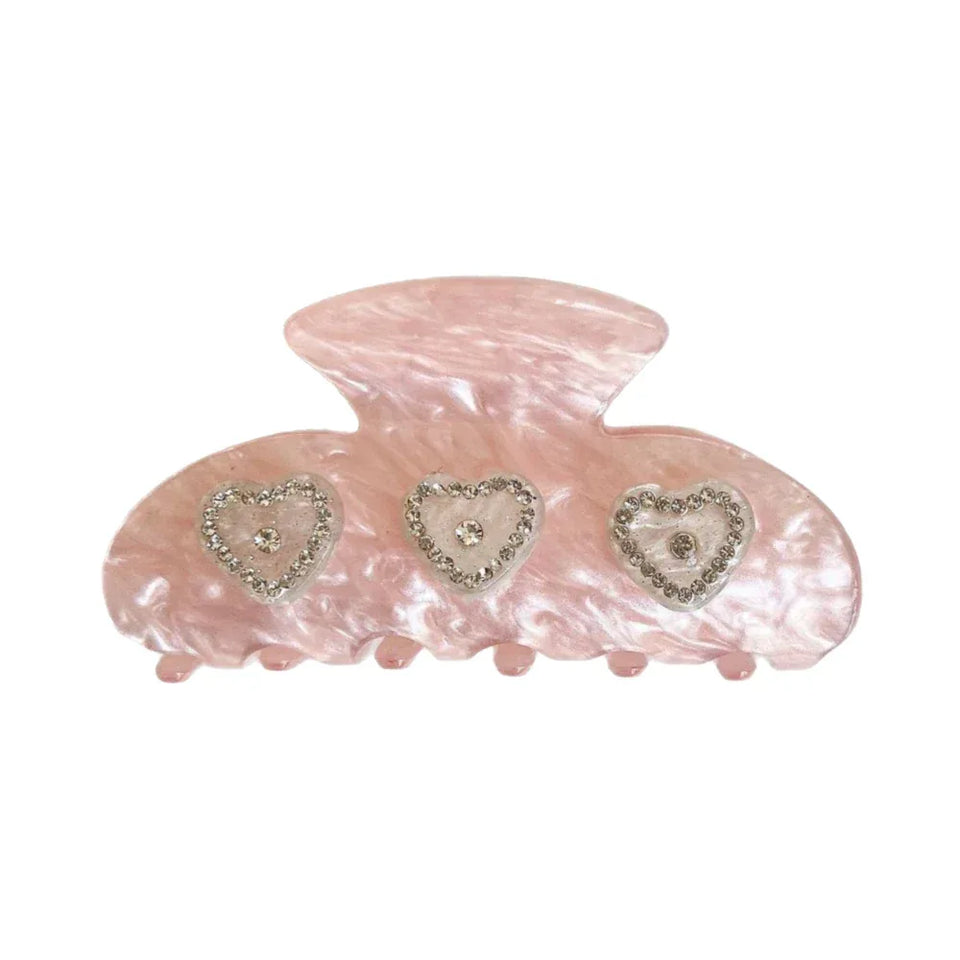 Pink marble claw clip with three heart-shaped embellishments adorned with rhinestones Main image