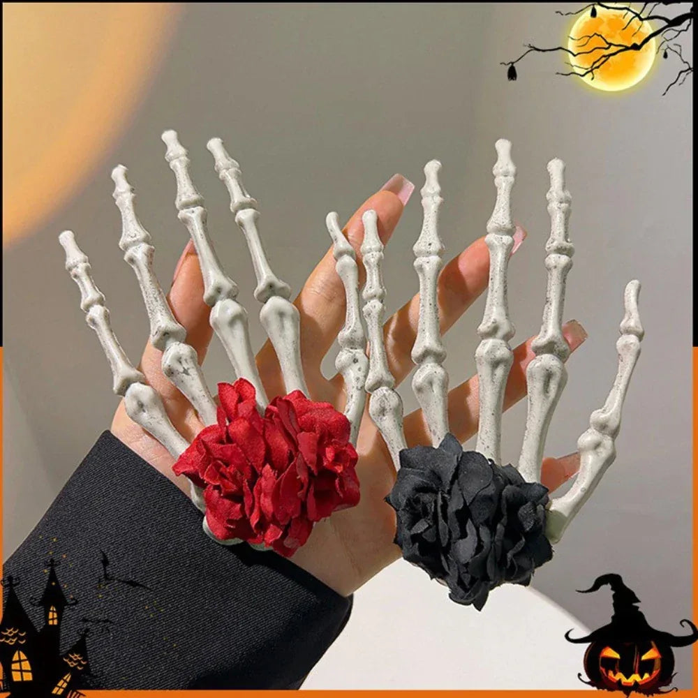 Two skeleton hand hair clips, one with a red flower and one with a black flower