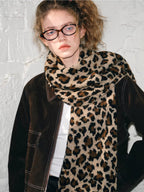 Close-up of a model wearing a leopard print scarf and a brown jacket.