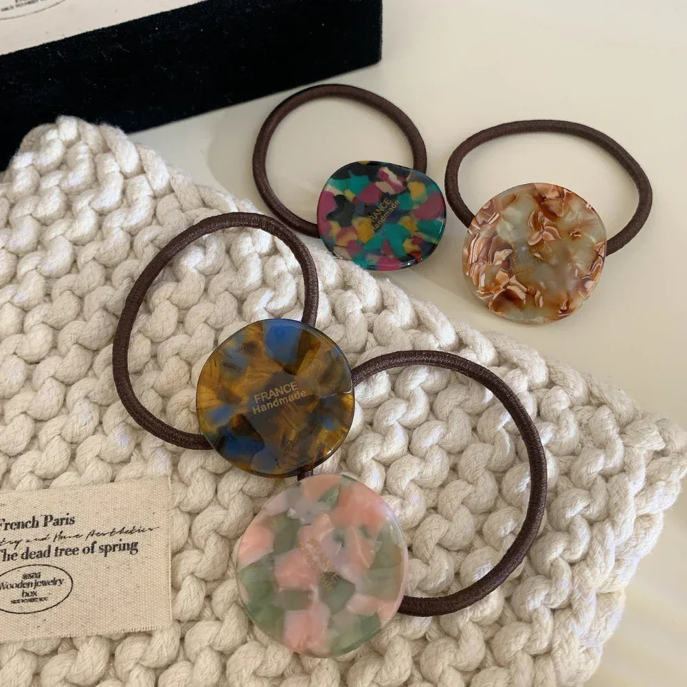Collection of four marbled round charm hair ties in various colors