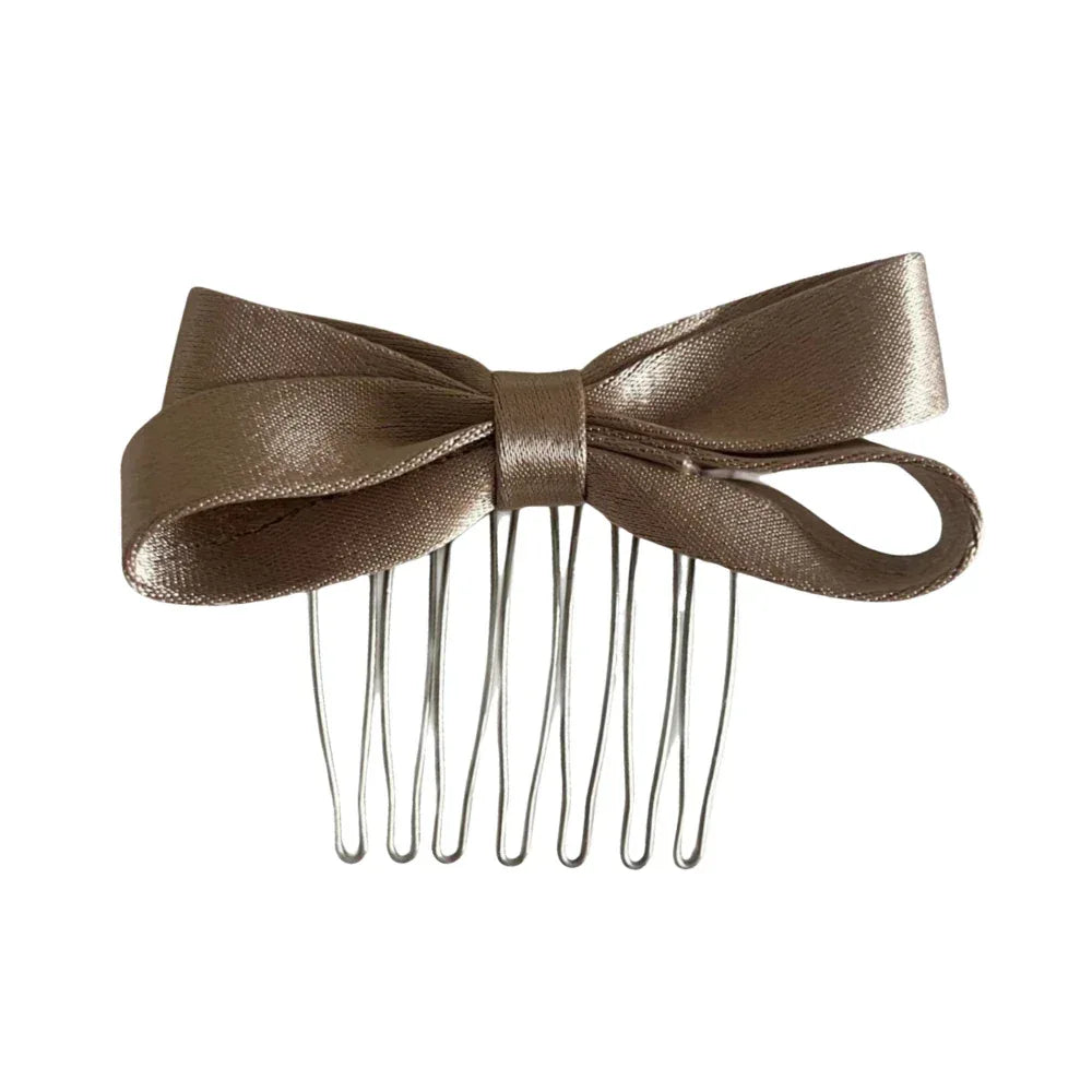 A single satin bow hair comb in a champagne color.