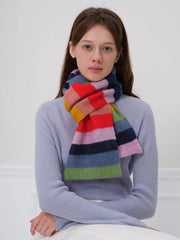 Woman wearing a blue sweater and a colorful striped scarf