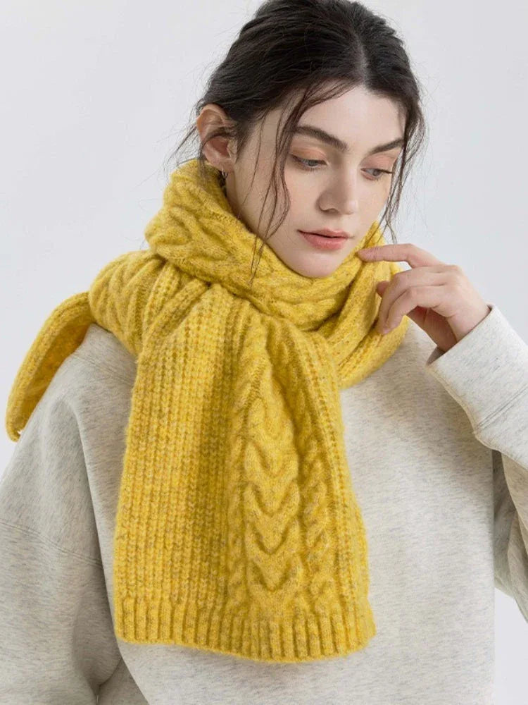 Woman adjusting her yellow cable knit scarf