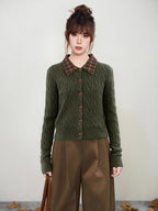 Woman wearing a green cable knit cardigan with a plaid collar