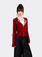 Woman in a red knit cardigan with white trim, white t-shirt, and dark wash wide-leg jeans, holding a black backpack
