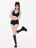 Model wearing a black bikini top, black ruffled shorts, and black platform boots.