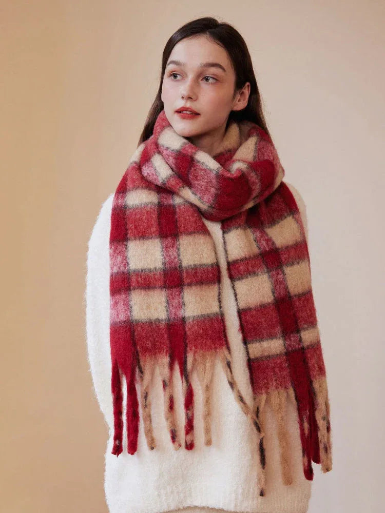 Woman wearing a red and cream plaid scarf draped around her neck, styled with a white sweater.