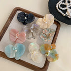 Top-down view of decorative hair clips and pearl necklaces.