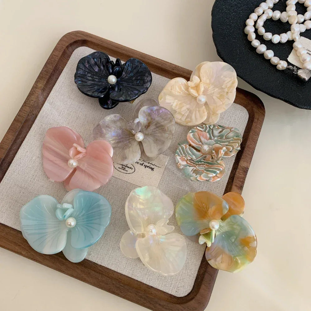 Top-down view of decorative hair clips and pearl necklaces.
