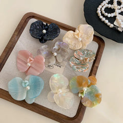 Top-down view of decorative hair clips and pearl necklaces.