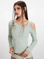Close-up of a woman's upper body, highlighting the intricate neckline and shoulder detail of the mint green long-sleeved top.