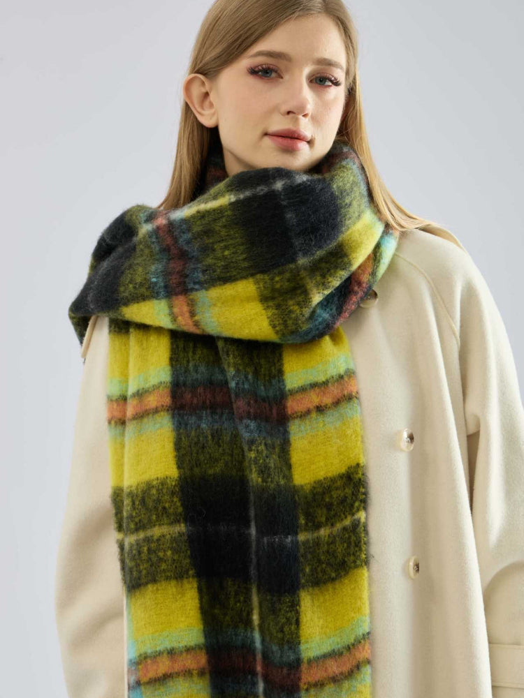 Close-up of a woman's face and shoulders, wearing a yellow and black plaid scarf.