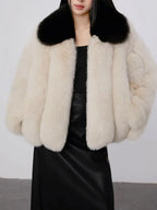 Front view of a cream faux fur cropped jacket with a black collar.