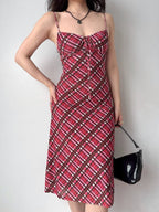 Front view of a woman in a red plaid midi dress, showcasing the fitted silhouette and spaghetti straps.