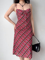 Front view of a woman in a red plaid midi dress, showcasing the fitted silhouette and spaghetti straps.