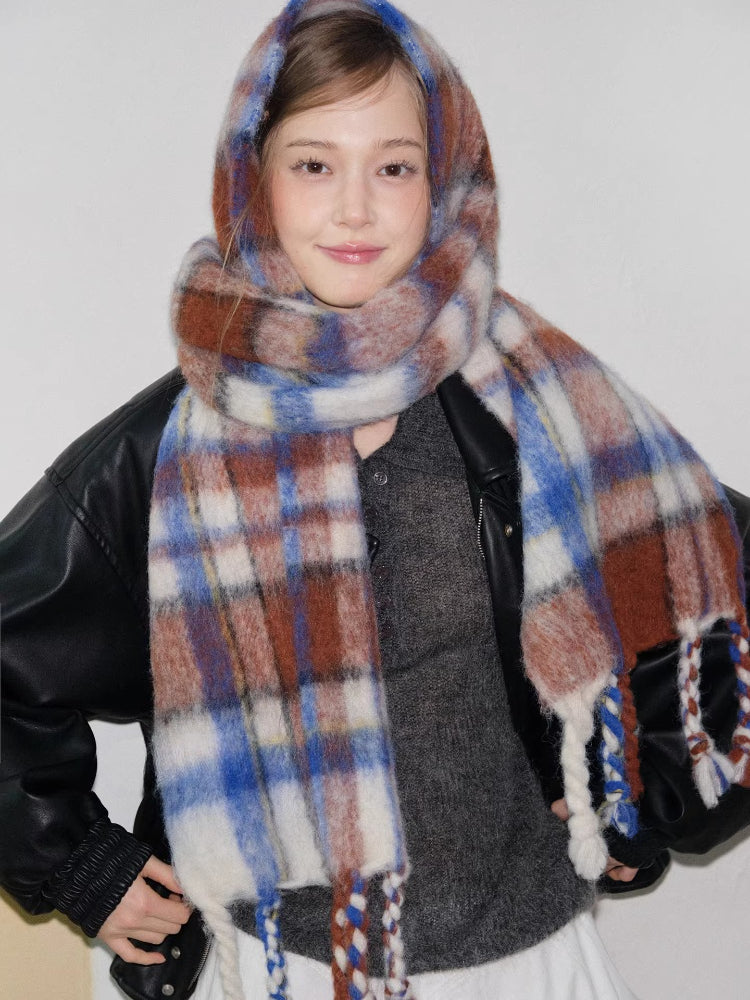 Close-up of a model smiling and wearing a colorful plaid scarf.