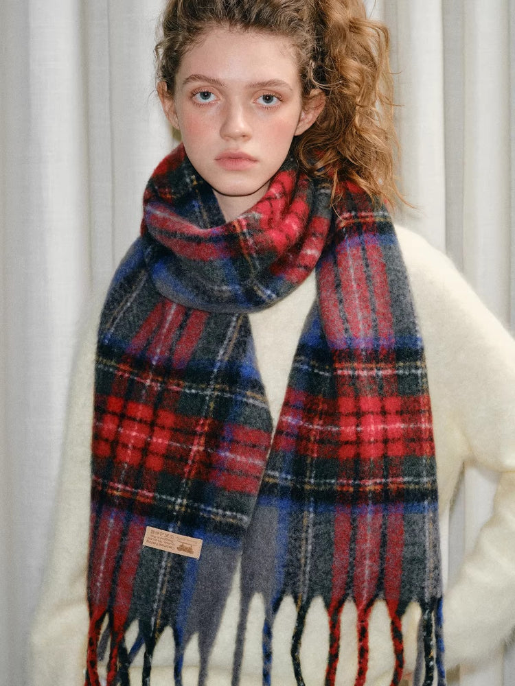 Full body shot of a young woman in a cream sweater, white skirt, white socks, and a tartan plaid scarf.