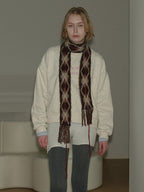 Model wearing a cream sweatshirt, argyle scarf, and grey leggings