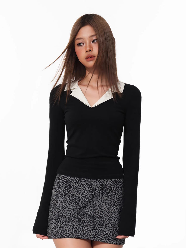 Close-up of a model wearing a black long-sleeved top with a white contrast collar.