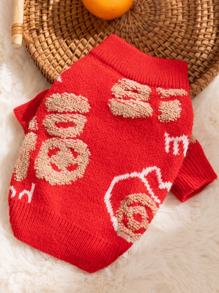 A red knit dog sweater with gold embroidered Chinese characters laid flat.