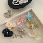 A collection of colorful floral hair clips arranged in a tray.