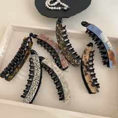 Group of elegant banana hair clips laid out on a tray