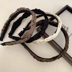 Collection of braided headbands in brown, black, and cream