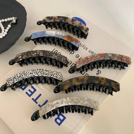 Assortment of marbled acetate banana hair clips in various colors and patterns