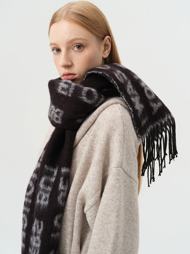 Close-up of a woman's face and shoulder wearing a black scarf with white text