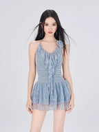 Full-body view of a woman in a light blue ruffled halter dress, front view.