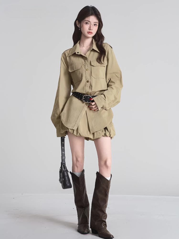 A model showcases a tan shirt dress with a gathered skirt, black studded belt, grey socks, and dark brown boots.