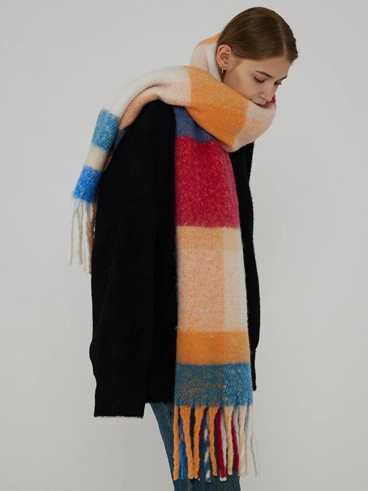 Woman in a black sweater and a colorful plaid scarf, looking down