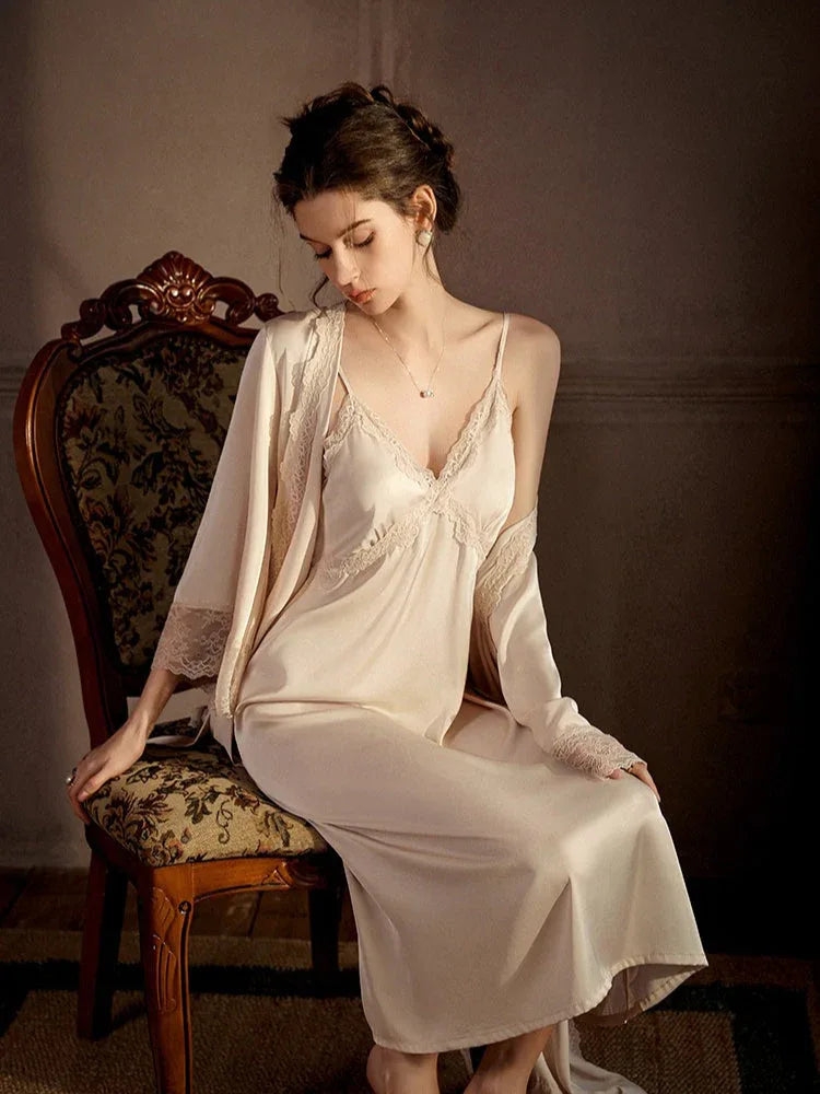 Woman wearing a cream satin slip dress with lace trim and a matching robe, seated on an ornate chair. Main image