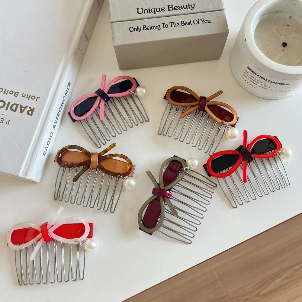 A flat lay of assorted hair combs, each adorned with a bow and a single pearl.