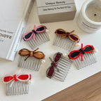 A flat lay of assorted hair combs, each adorned with a bow and a single pearl.