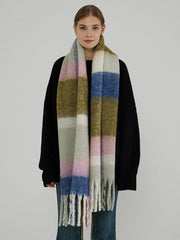 Woman wearing a black sweater and a large plaid scarf with green, pink, blue, and white blocks.