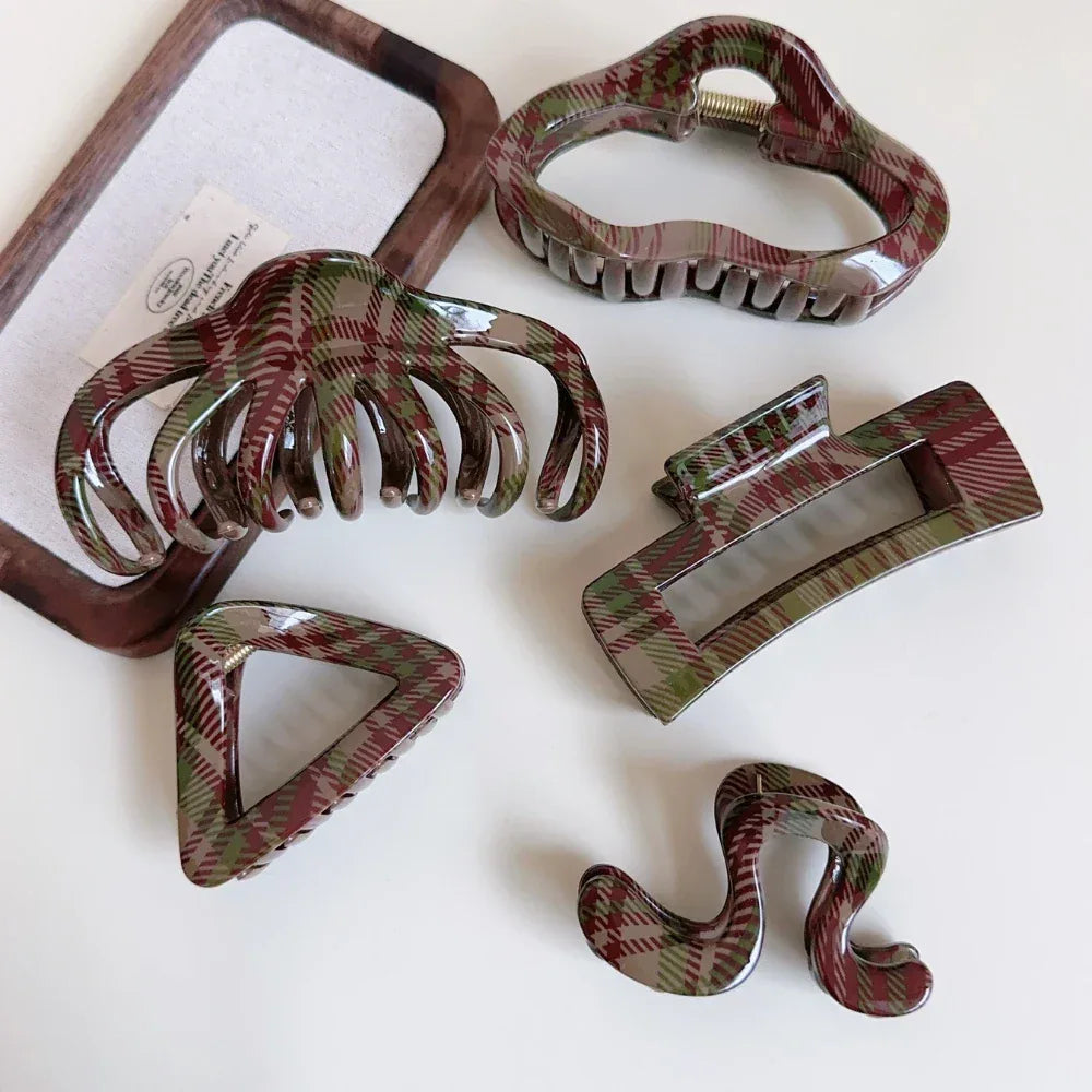 Various plaid hair claw clips arranged on a surface