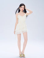 Full-length shot of a woman in a white chiffon dress with ruffled details