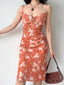 Woman adjusting her floral print midi slip dress, showing the flowy hem.