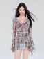 Woman wearing a long-sleeved, plaid mesh mini dress with a tie-front detail and flared sleeves.