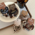 A collection of Henju hair ties displayed on a white plate and a tray.