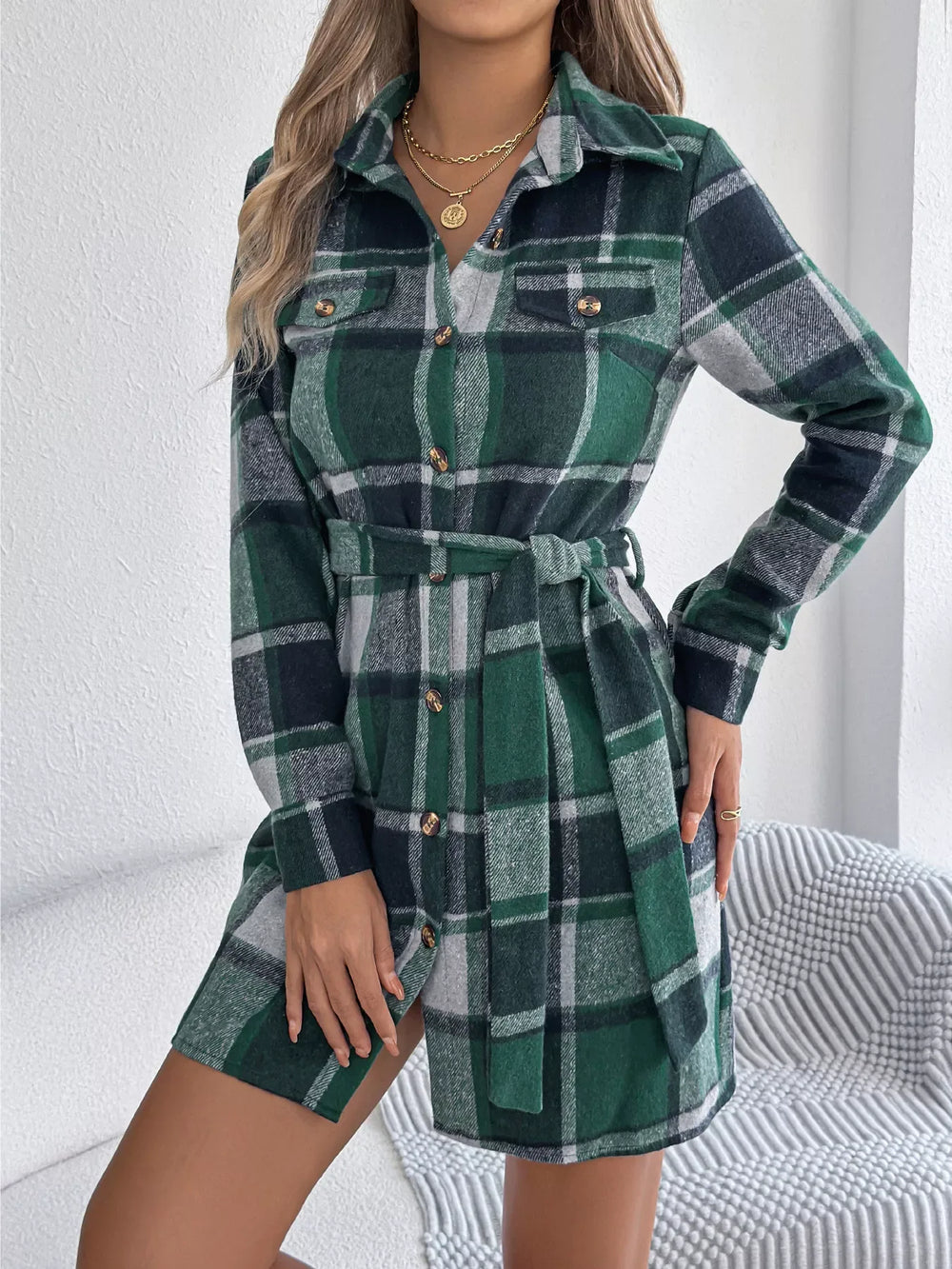 Woman wearing a green plaid long-sleeve belted shirt dress
