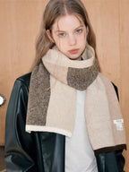 Detailed view of a plaid knit scarf with a brand tag.